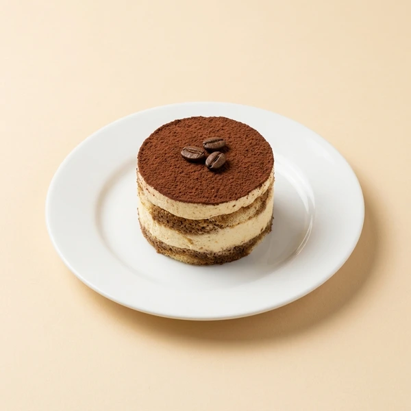 Artisanal layered mini tiramisu cake with cocoa dust and roasted coffee beans