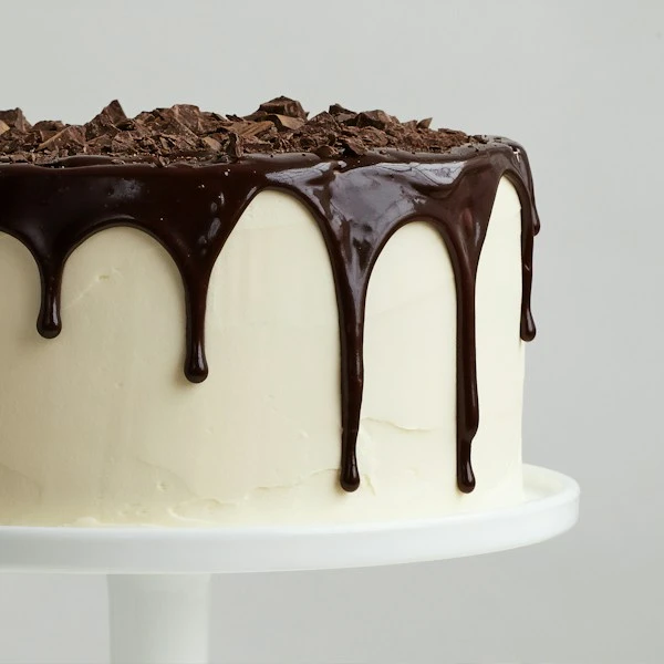 Delicate vanilla cream layered mini cake with white curls